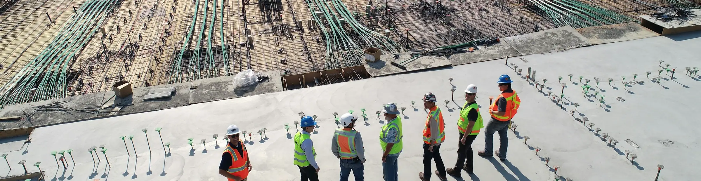 Équipe de chantier réunie sur une dalle en cours de ferraillage, avant coulage du béton.