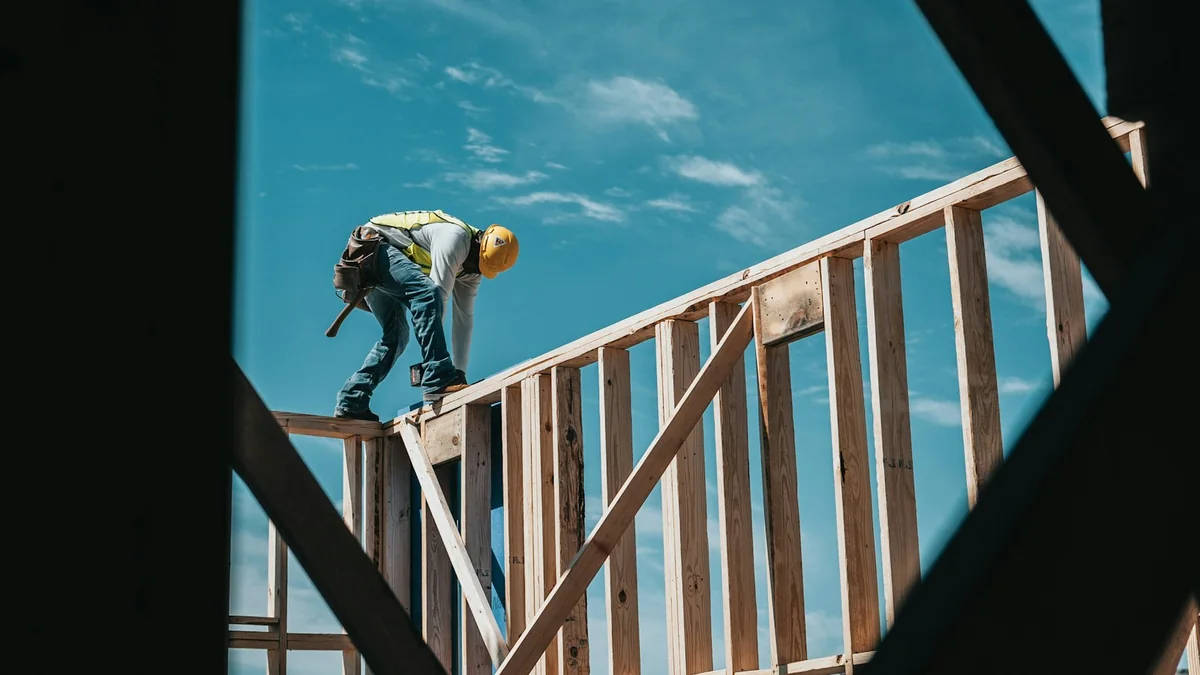 Charpentier travaillant sur l'ossature bois d'une construction.